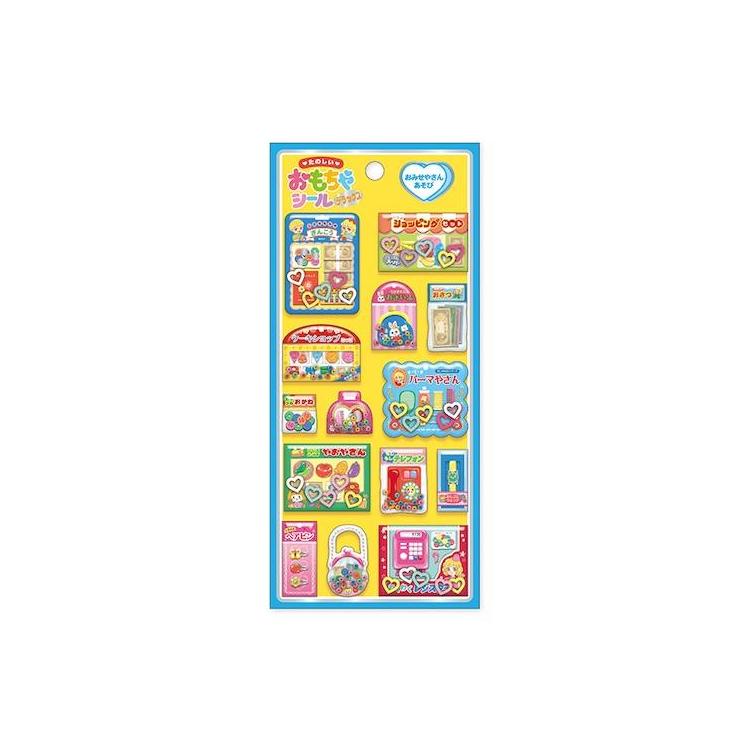 たのしいおもちゃシールデラックス「おみせやさんあそび」の商品画像。黄色の台紙にお店屋さんごっこをモチーフにしたカラフルな立体シールをデザイン