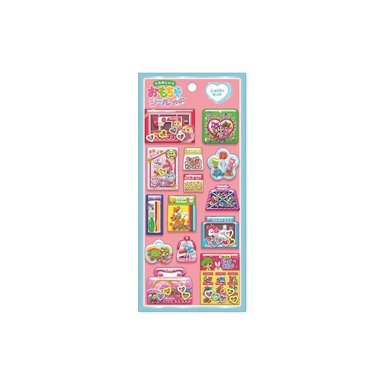 たのしいおもちゃシールデラックス「しゅげいセット」の商品画像。ピンクの台紙に手芸やおしゃれ遊びをモチーフにした立体シールをデザイン
